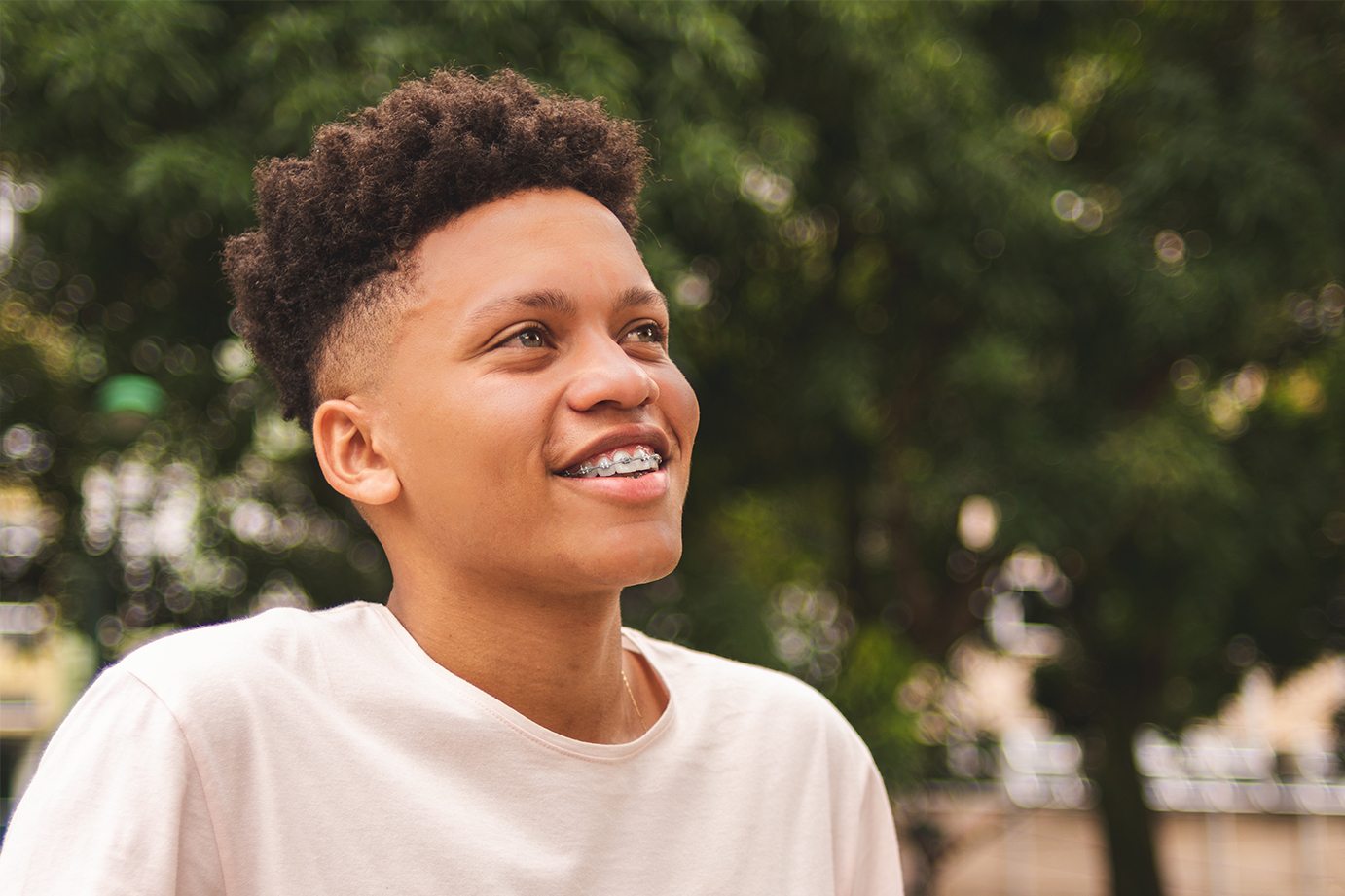 Teen boy with braces outside